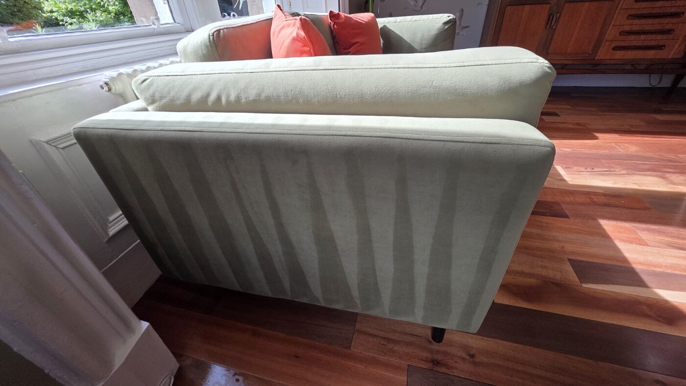 Freshly cleaned pale green couch finished with neat extraction lines